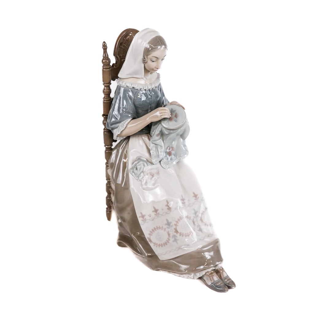 Lladro Spanish Porcelain Figure: Lladro Spanish porcelain figure, "Bordadora", #4865, modeled as a lady sitting with embroidery, marked to base. [11 1/2" H x 8 3/4" W x 5" D]. In overall good condition with minor wear.