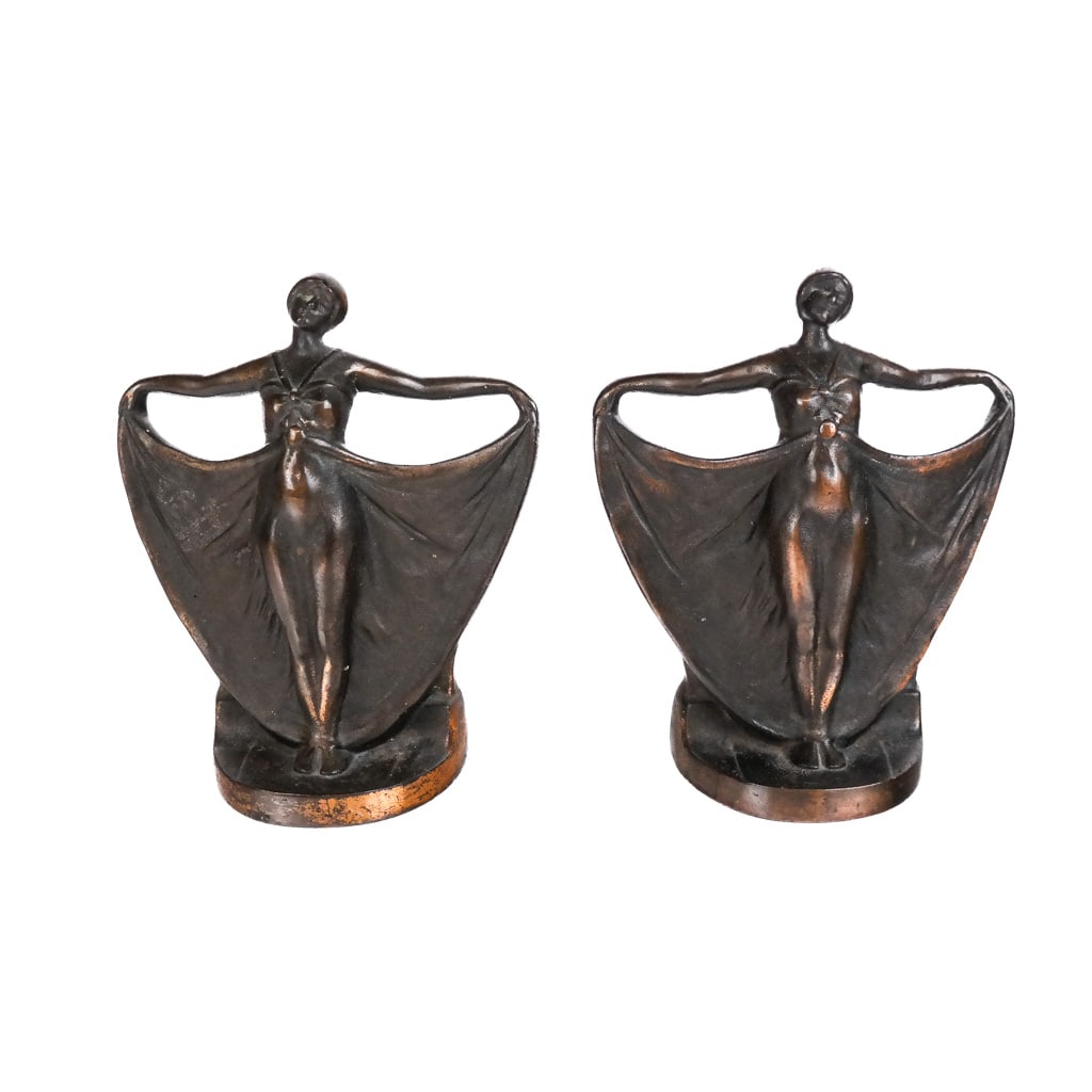 Pair of Art Deco Bronze & Iron Doorstops: Pair of Art Deco bronze and cast iron doorstops or bookends, circa 1920, each modeled as a dancer with billowing dress, unmarked. [9" H x 8" W x 3 1/2" D].