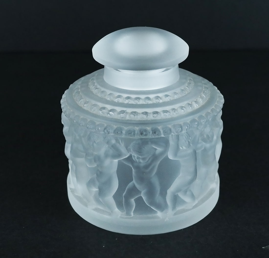 Signed Lalique, France Frosted Glass Bottle: Lalique, France frosted glass bottle, "Enfants", with scenic details of frolicking children, bearing etched signature to base. [4 1/4" H x 4" Diam.]. Chips to stopper base; scuffs to stopper and base.