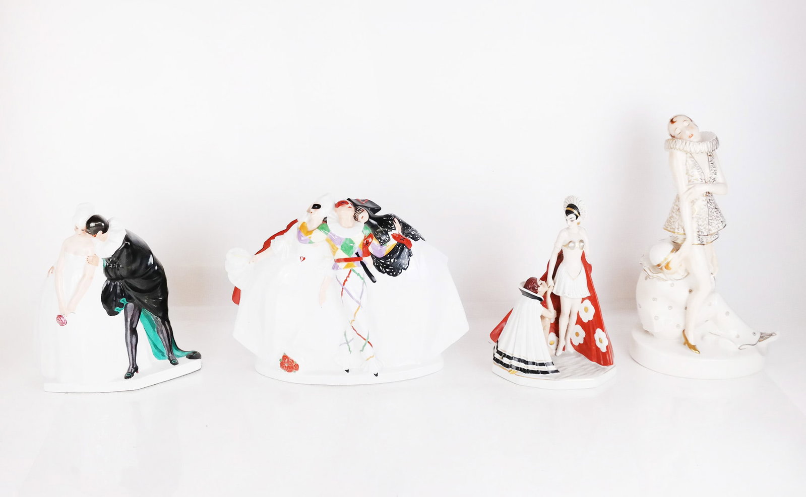 Group of 4 Art Deco Porcelain Sculptures: Group of four (4) Art Deco porcelain sculptures, each modeled with courting couples and lovers, dressed as Pierrot clowns, harlequins and jesters, two by Leon Leyritz from Commedia dell'Arte and two u