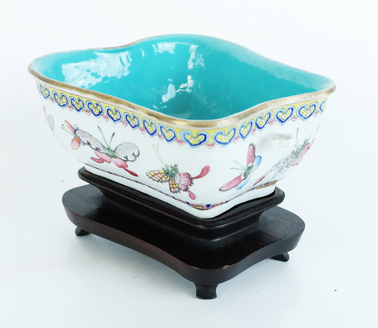 Chinese Porcelain Oblong Bowl on Stand: Chinese porcelain oblong bowl on stand, having turquoise glaze interior in odd oblong shape, with butterfly and heart enamel trim, on fitted stand. [Overall: 5" H x 8" W x 6 1/2" D]. Bowl not perfectl
