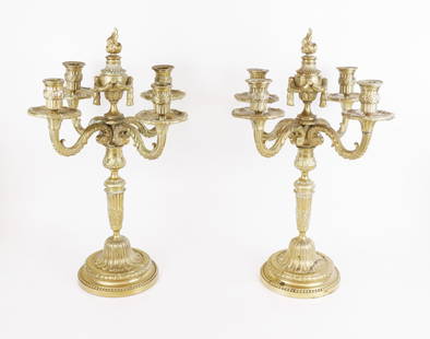 Pair of Louis XVI-Style Gilt Bronze Candelabra: Pair of Louis XVI-style gilt bronze candelabra, 20th century, after a model by Jean-Joseph de Saint Germain (French, 1719-1791) with foliate accented candle cups and removable flambeau finials. [21" H