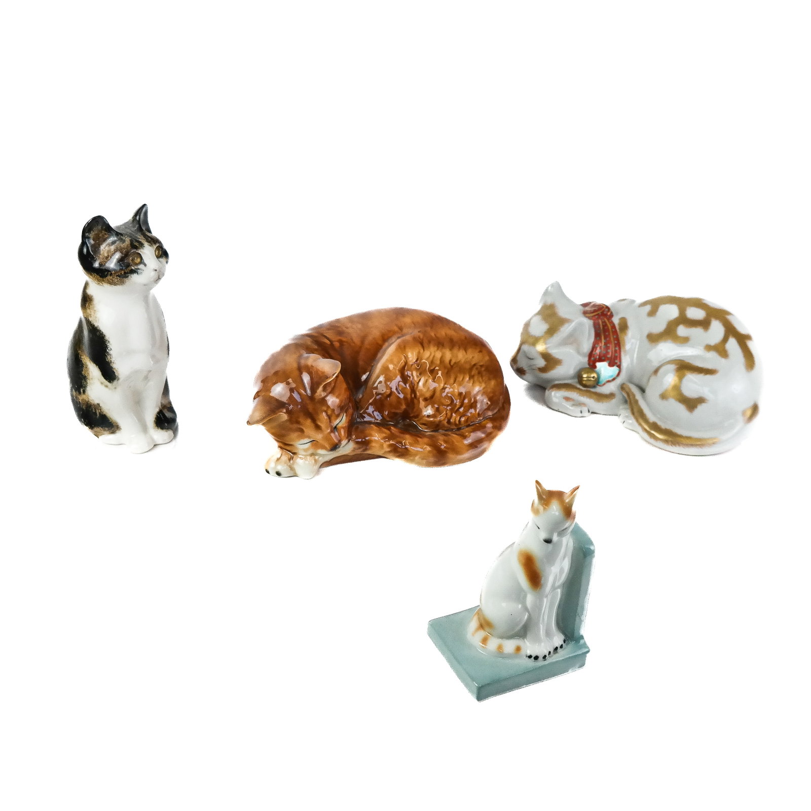 Four Porcelain Cats: Four porcelain cats in assorted poses and various origins. [Tallest: 8" H].