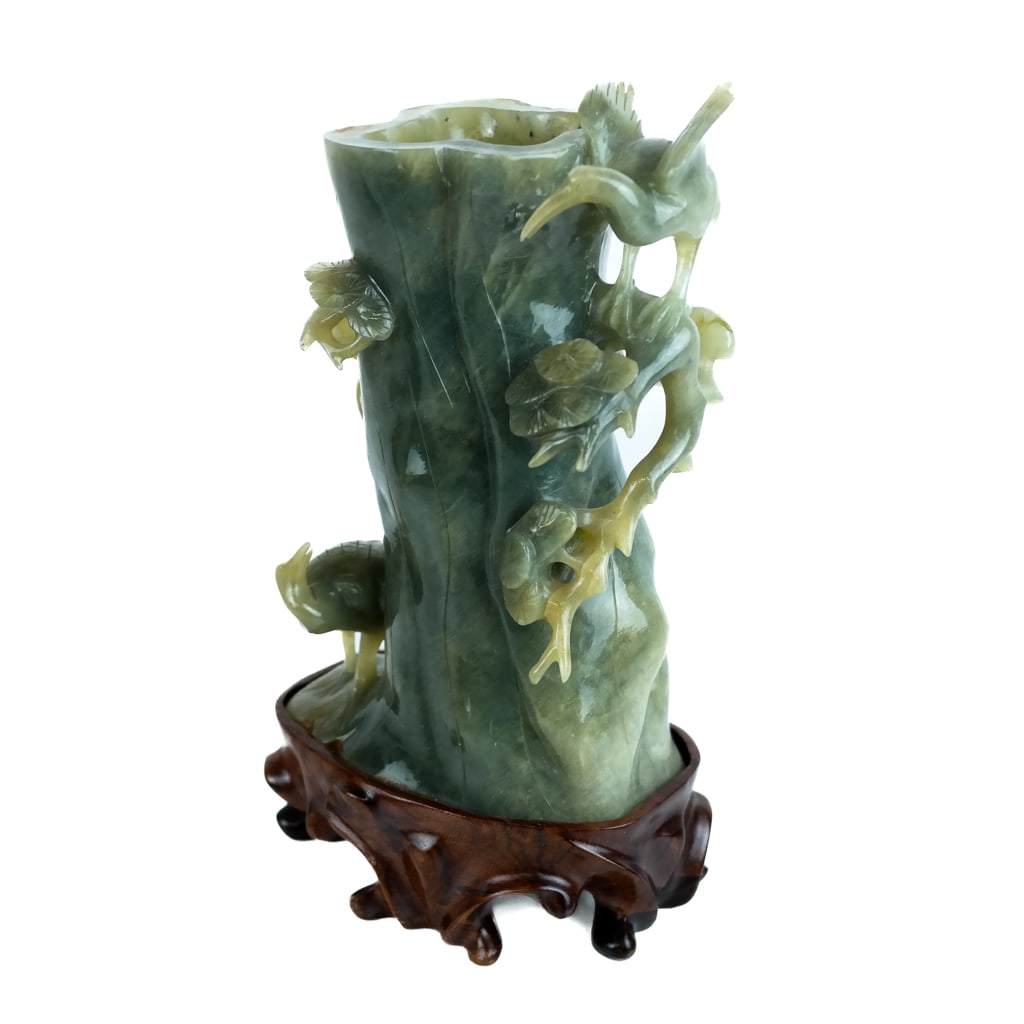 Chinese Carved Jade Vase: Chinese carved jade vase, 20th century, modeled as a tree with climbing flowers and bird, on a conforming wood base. [Overall: 7 3/4" H x 4 1/2" W x 3" D]. Mounted to stand; in overall good condition.