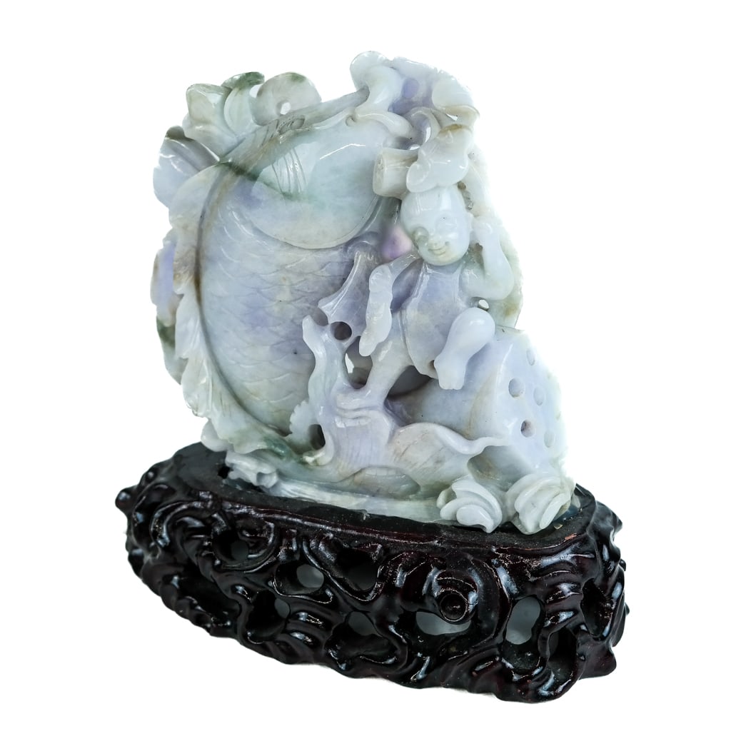 Chinese Carved Lavender Jade Sculpture: Chinese carved lavender jade sculpture, 20th century, modeled as a koi fish with a man, with lotus roots and a disc, on a conforming wood base. [Overall: 6 3/4" H x 6 1/2" W x 2 3/4" D]. Mounted to st