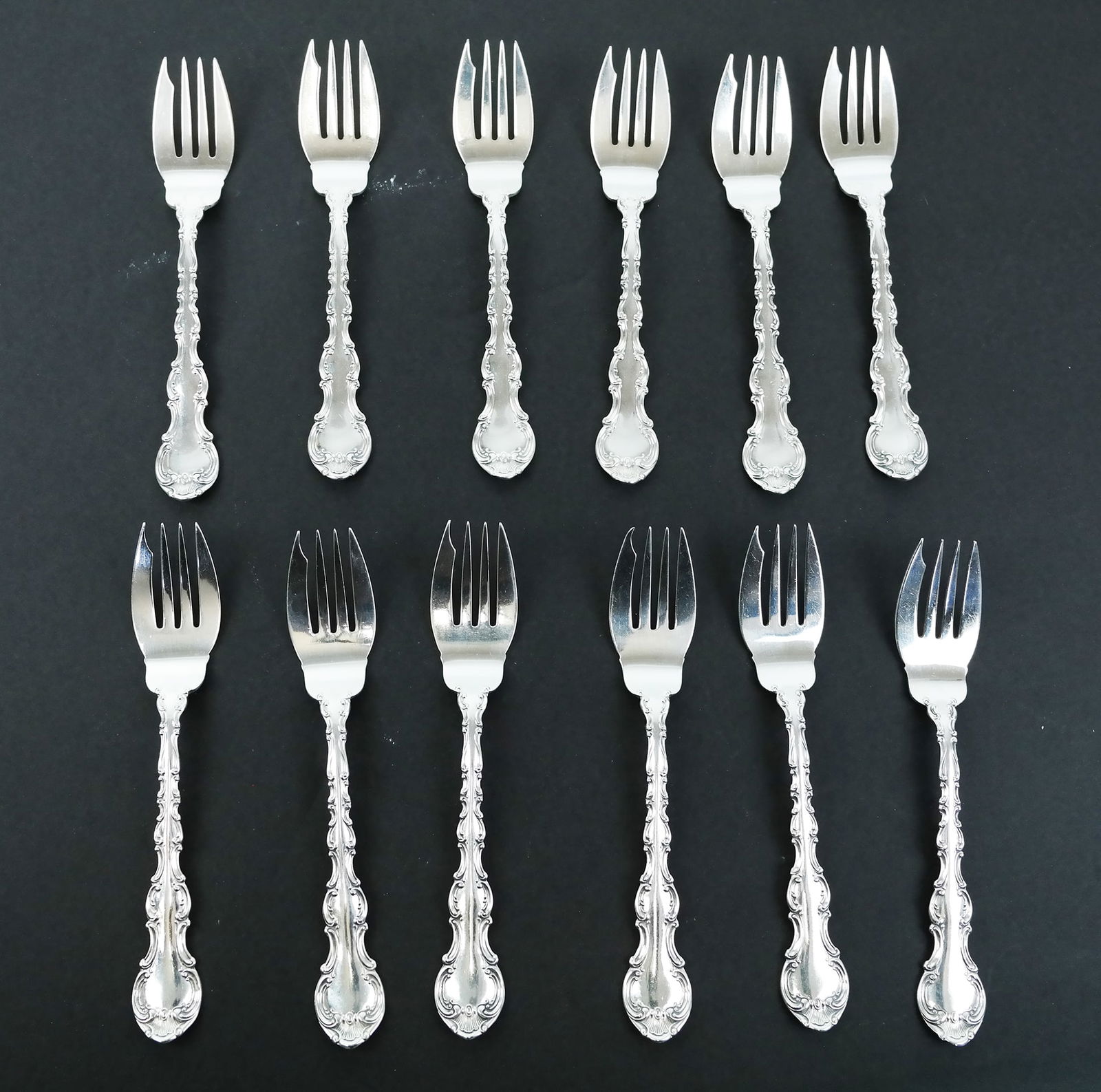 Twelve Sterling Silver Salad Forks: Set of twelve (12) 20th century English sterling silver salad forks, manufactured by Gorham. Each: 1.30 ozt.; 15.6 ozt. total weight. [Each: 6 3/8" L]. In good condition.