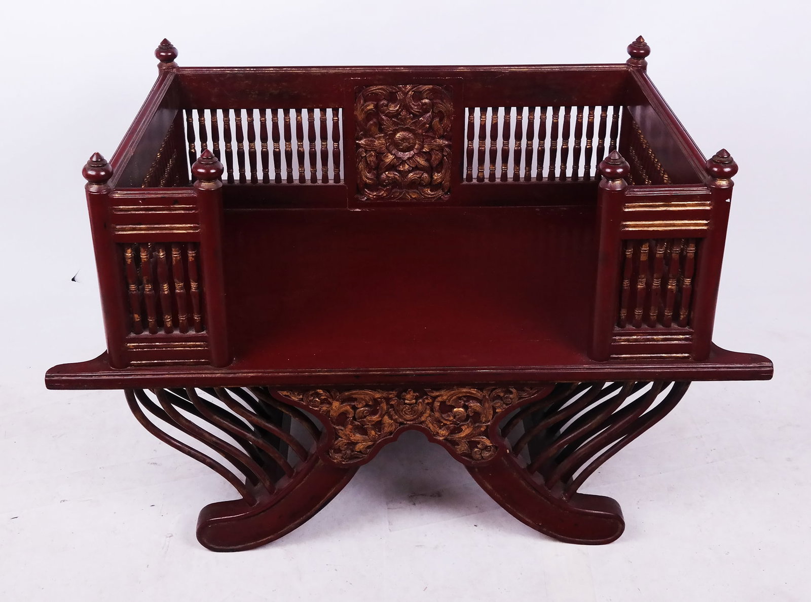 Thai Carved and Painted Elephant Saddle: Elephant saddle, painted and gilt, with spindle seat gallery and splay legs. [29" H x 24" W x 42" D].