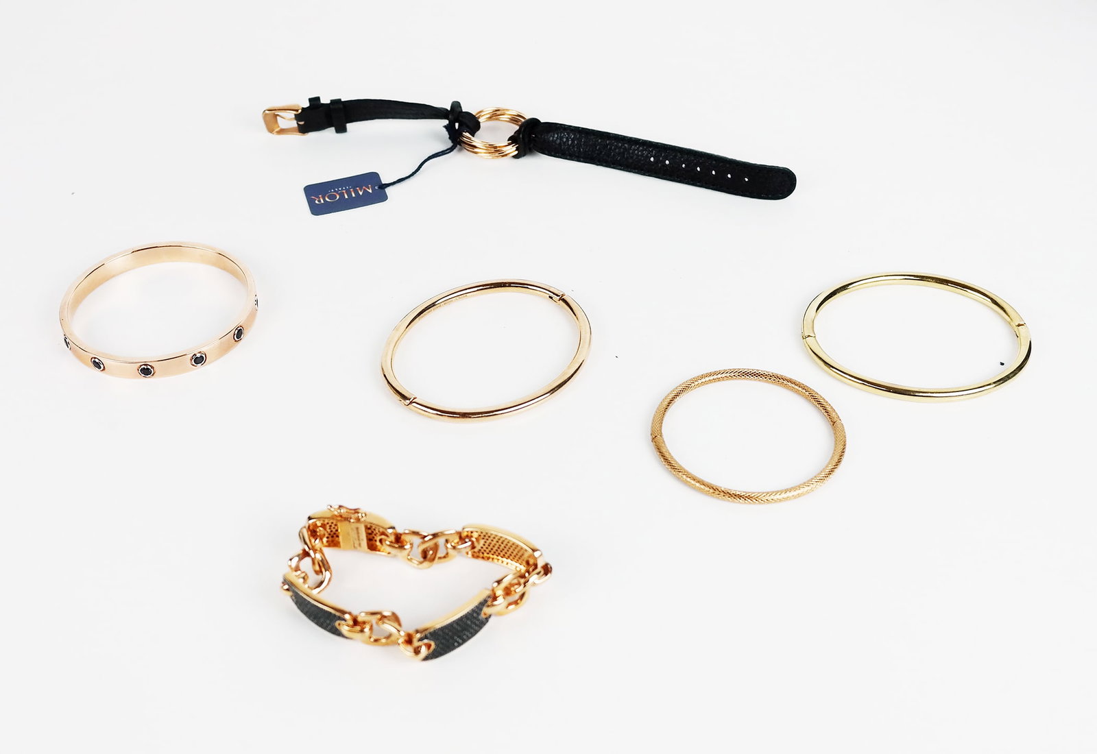 6 Pcs. Milor Italy Costume Jewelry: Stainless steel and bronze bracelets and two other bracelets, all gold tone, one "O" bracelet unmarked.