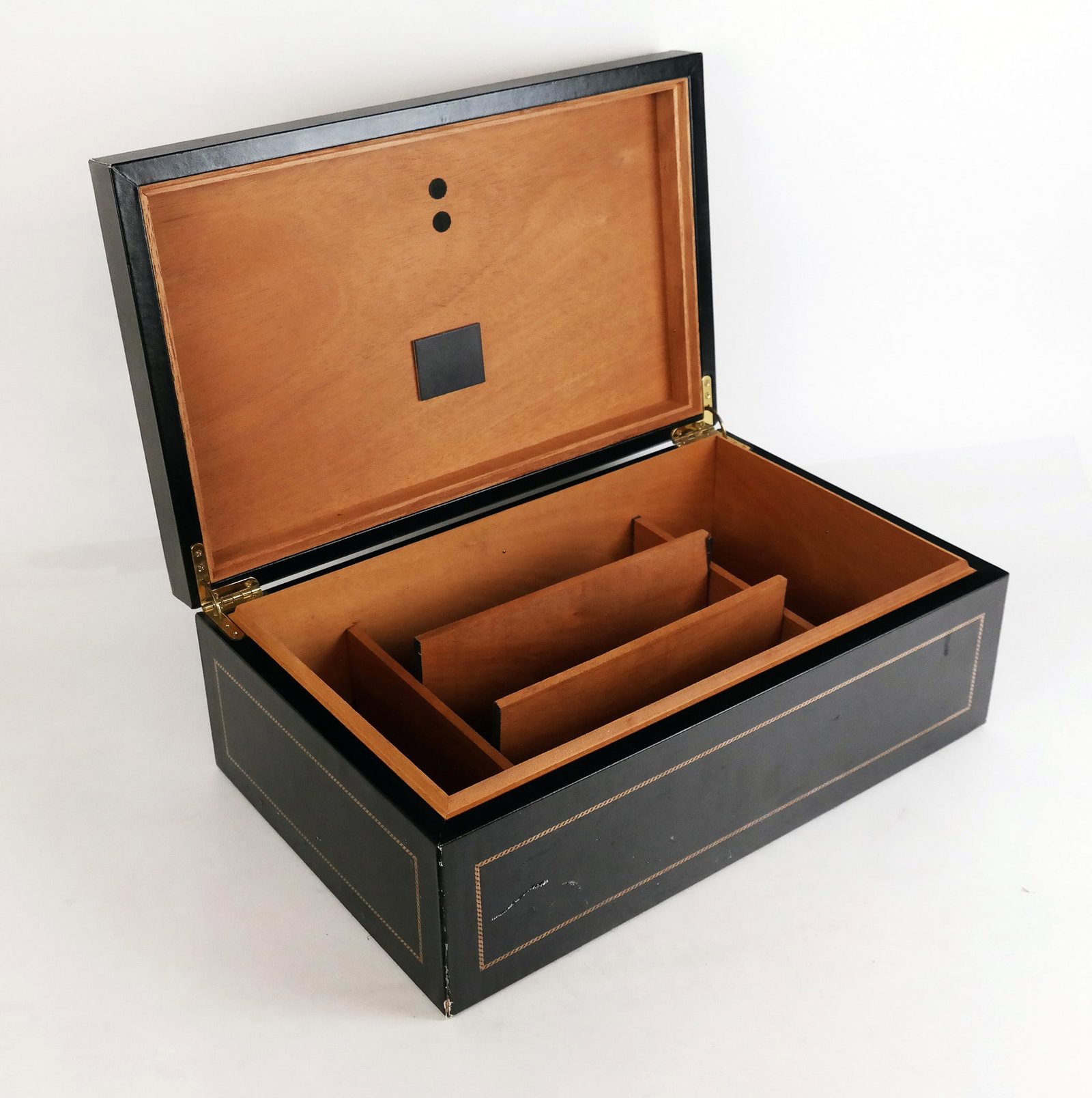 Black Leather Humidor Case: Black leather humidor case having gilt tooled details, the interior with adjustable dividers, unsigned. [6" H x 16 1/4" W x 10 1/2" D]. Overall with scattered marks and wear.