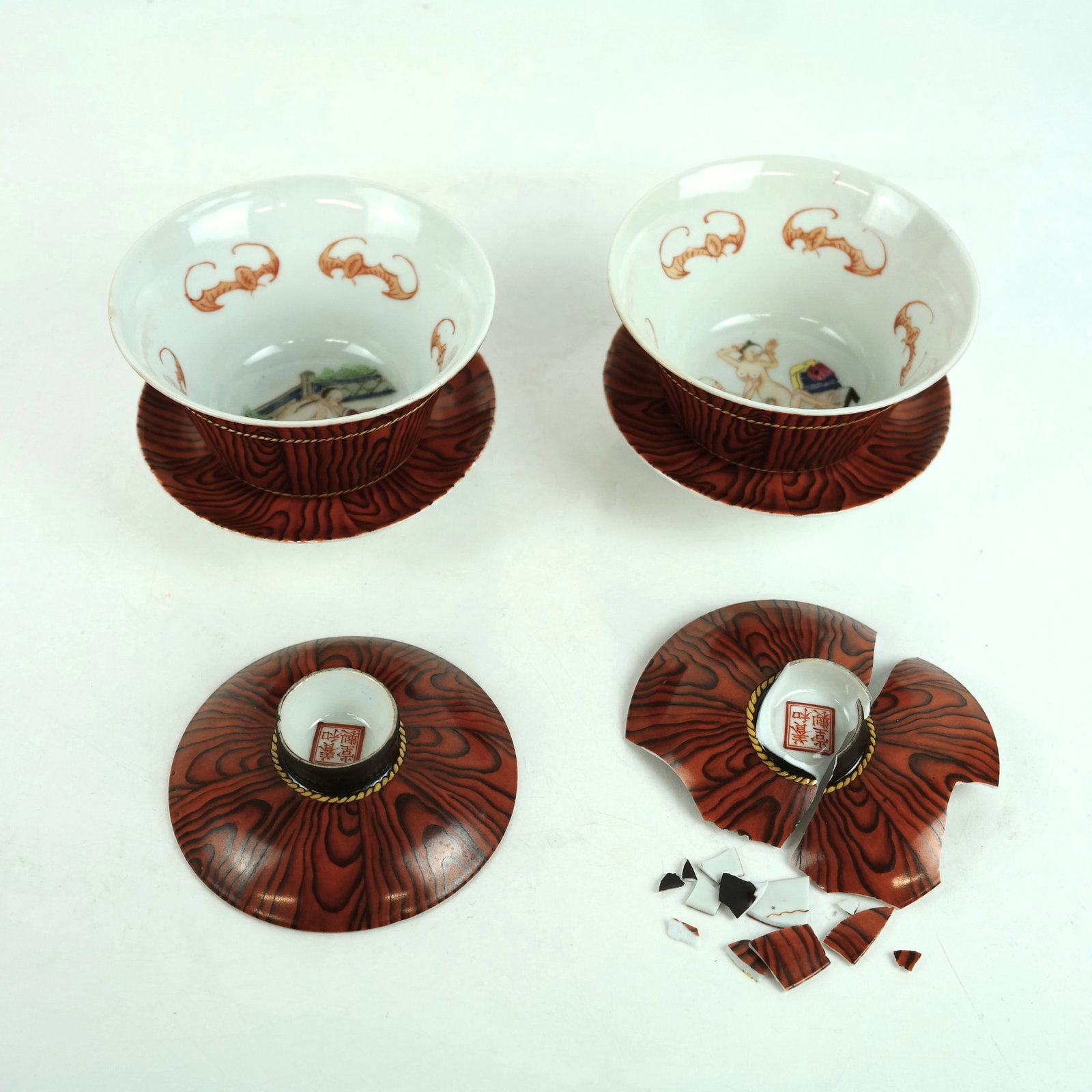 Pair of Chinese Porcelain Erotic Gaiwan Teacups: Pair of Chinese porcelain erotic gaiwan teacups, each with painted faux grain details centered with scenes of couples captured in an intimate moment, bordered with auspicious bianfu bats, representing