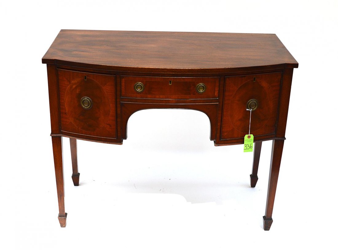 Hepplewhite Style Server: Hepplewhite style mahogany bow front server, raised on tapered legs with spade feet, having two doors and a center drawer. Good condition. 42" x 22 1/2" x 34".