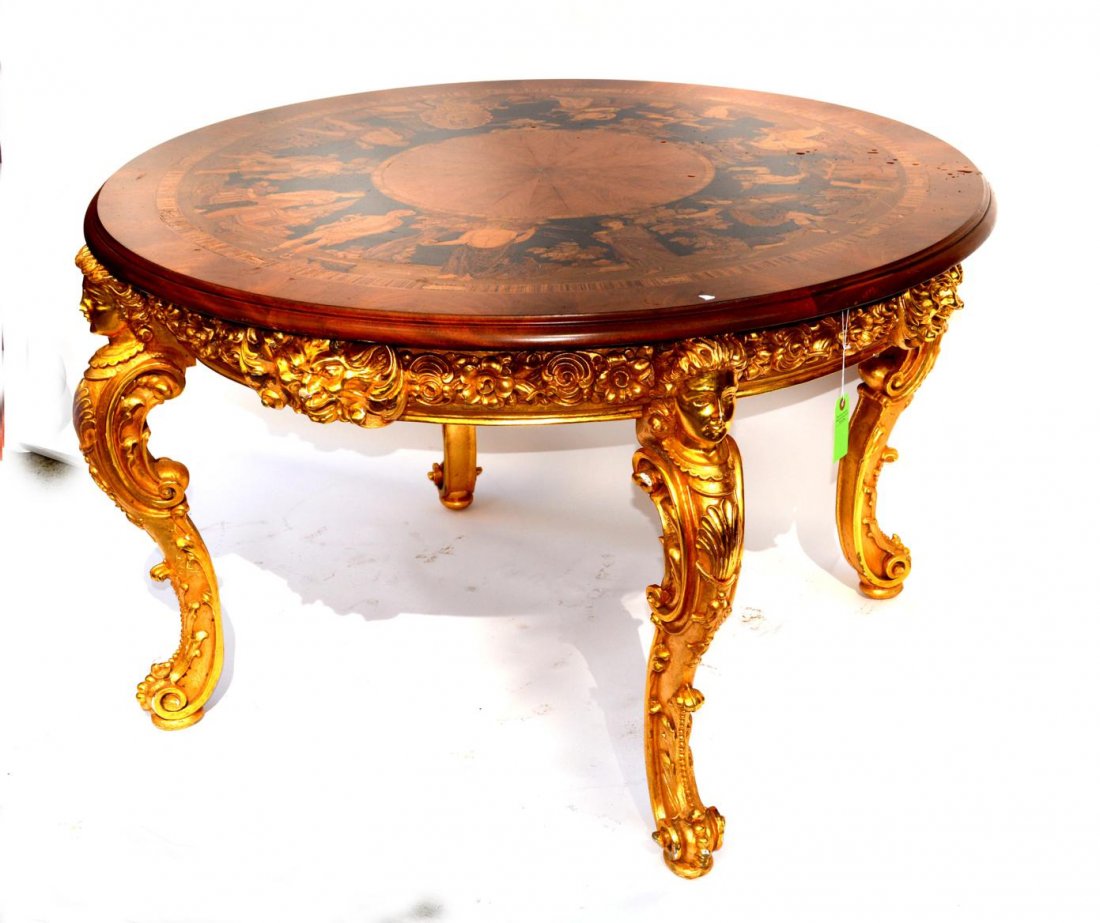 Neo-Classical Style Marquetry Center Table: Circular table with elaborate marquetry top depicting 12 Roman gods and goddesses among various flora and fauna. Features a boldly carved and gilt wood base with caryatid legs, Bacchus mask accents, a