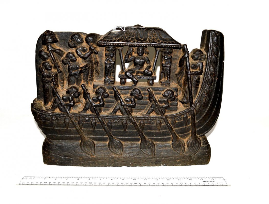 Balinese Carved Stone Sculpture: Carved black stone sculpture depicting ceremonial royal boat with ruler, attendants, and oarsmen. 18" W x 2 1/2" D x 13" H.