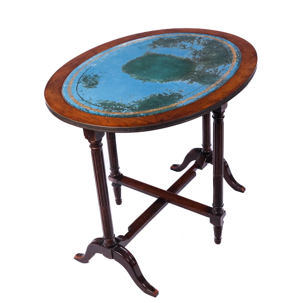 Antique Regency-Style Oval Tilt-Top Wine Table: Antique Regency-style oval wine table, having gilt metal trim on tooled leather and mahogany tilt top on swing fluted leg base and splay-leg lower legs. [41" H x 34" W x 15" D (up); 28" H x 34" W x 26