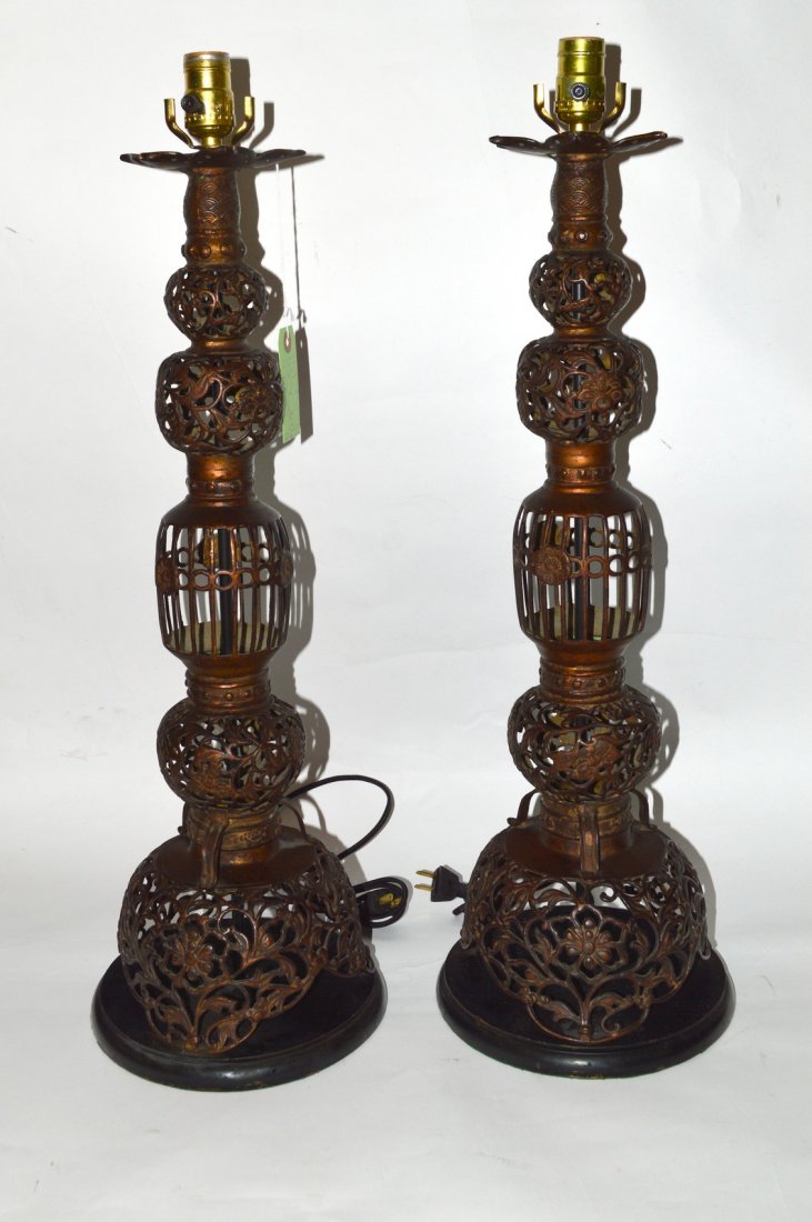 Pair of Modern Asian Inspired Table Lamps: Open work cast bronze table lamps. Each feature all-over lattice design with scrolling tendril and leafy rosette elements. 9" Dia at base x 28" 1/2" H to socket. In good condition.