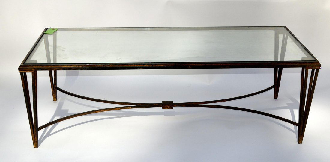 Modern Steel Glass Top Cocktail Table: Parcel-gilt steel low table on legs tapering toward bottom with cross stretchers. Glass bears a few small chips at edge. Otherwise in good condition. 48" W x 21" D x 15 3/8" H.