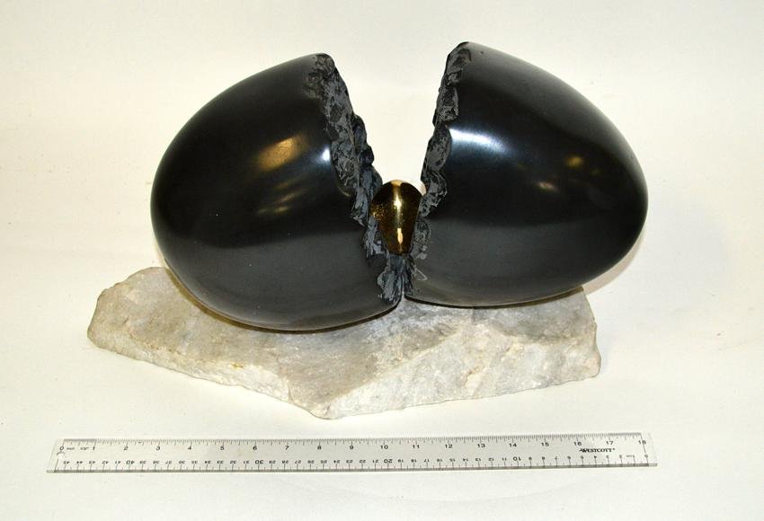 Modern Bronze and Stone Sculpture: Large soapstone egg represented as being split to reveal a smaller polished bronze egg. Mounted on an irregular shaped white marble base. 18"W x 8"D x 10.75"H.