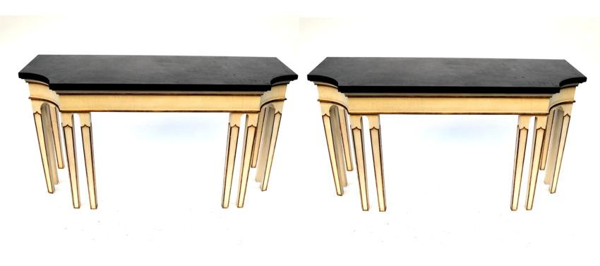 Pr. of Modern Black Stone Top Console Tables: Each bears a creme color 8 legged table base with gilt trim and matte polished stone top with concave corners. Some chips on tops. 56 1/4" x 20 3/4" x 30 1/4"H.
