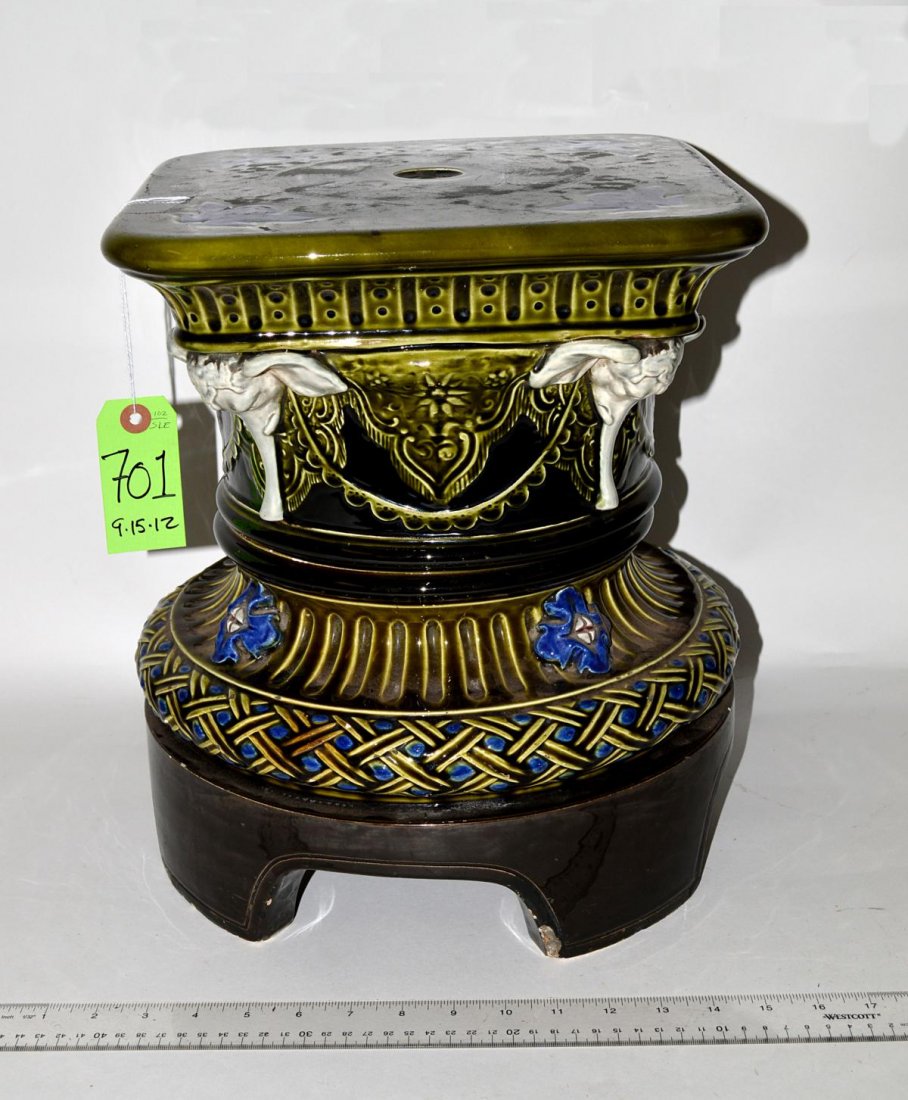 Glazed Ceramic Pedestal with Elephant Accents: Ornate pedestal with deep green glaze bearing elephant head accents. Top: 12" sq, base: 13 3/8" Dia x 14 3/4". In good condition.