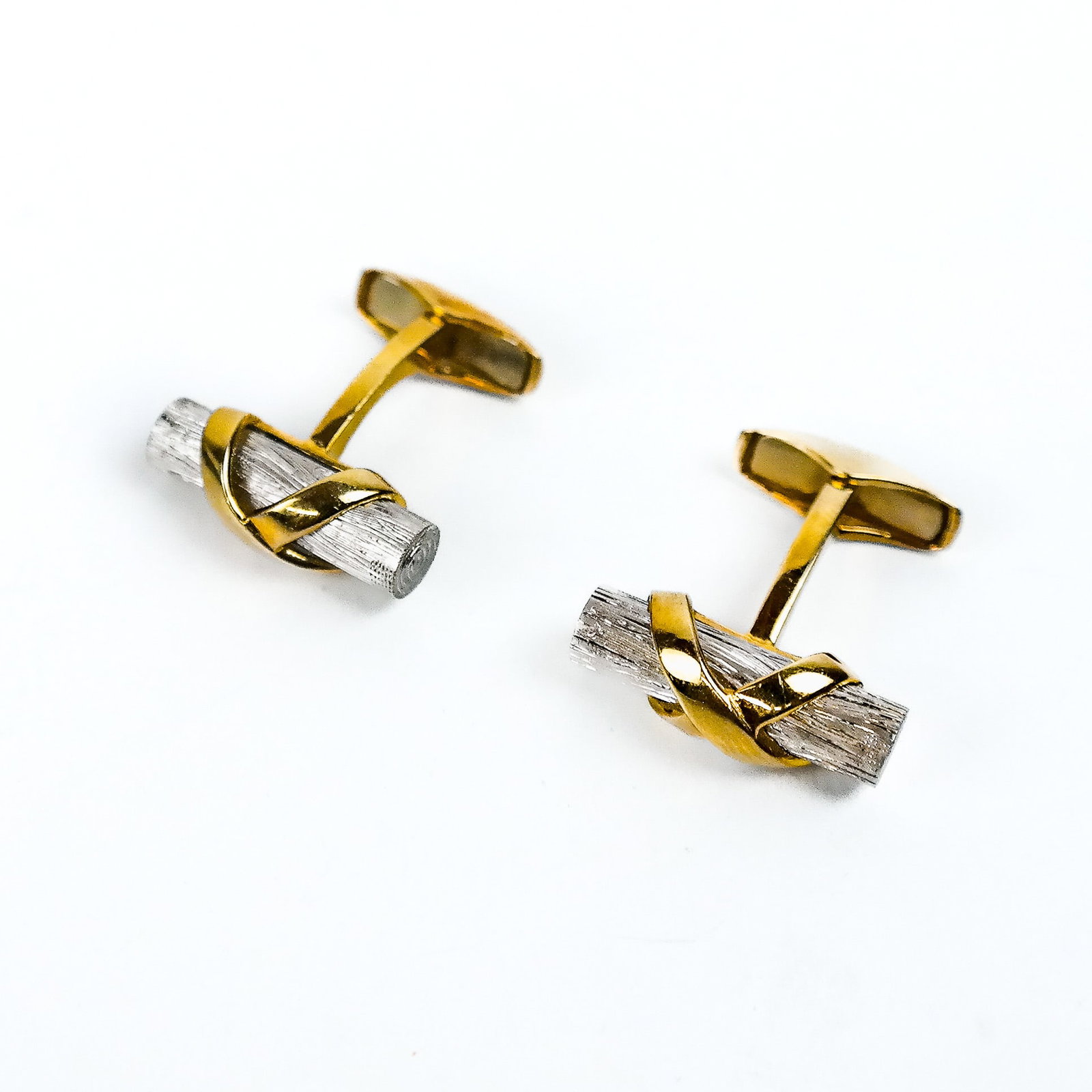 Pair of Bicolored Gold Cufflinks: Italian, designed as white gold logs with yellow gold straps, 18K gold, total 10.5 dwt. Provenance: From the Estate of Baroness Gabriele Langer von Langendorff.