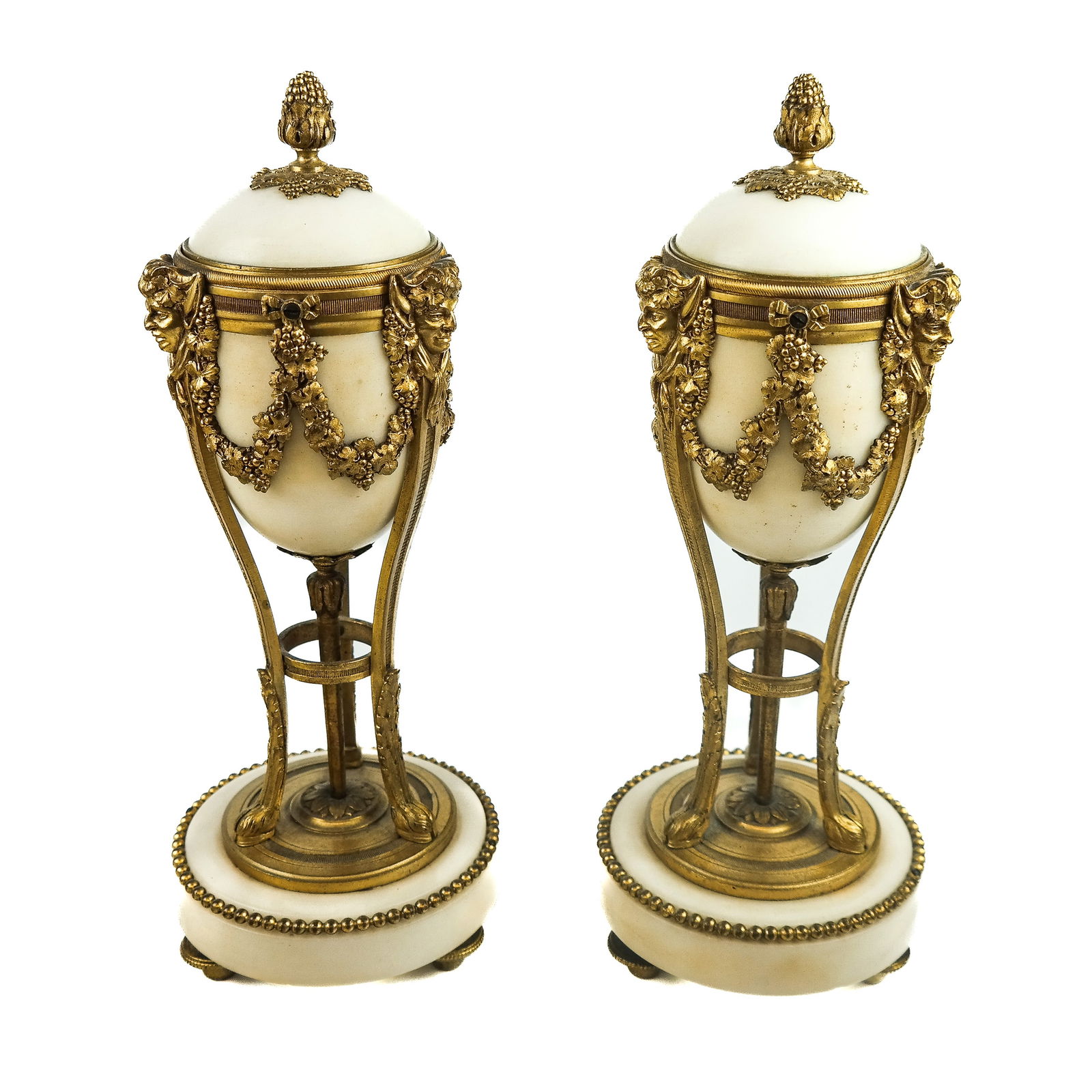 Pair of Marble & Gilt Bronze Cassolettes: A pair of white marble and gilt bronze cassolettes having attenuated Bacchus caryatid supports, raised on marble bases. Finials turn into candlesticks. [10 1/2" H x 4" Diam.]. Provenance: From the Est