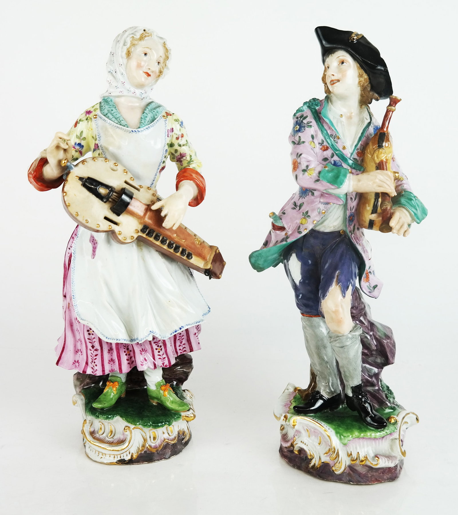 Pair of Meissen Male & Female Musicians: Pair of glazed porcelain musicians on scrolling bases. [13" H]. Repairs to hands.