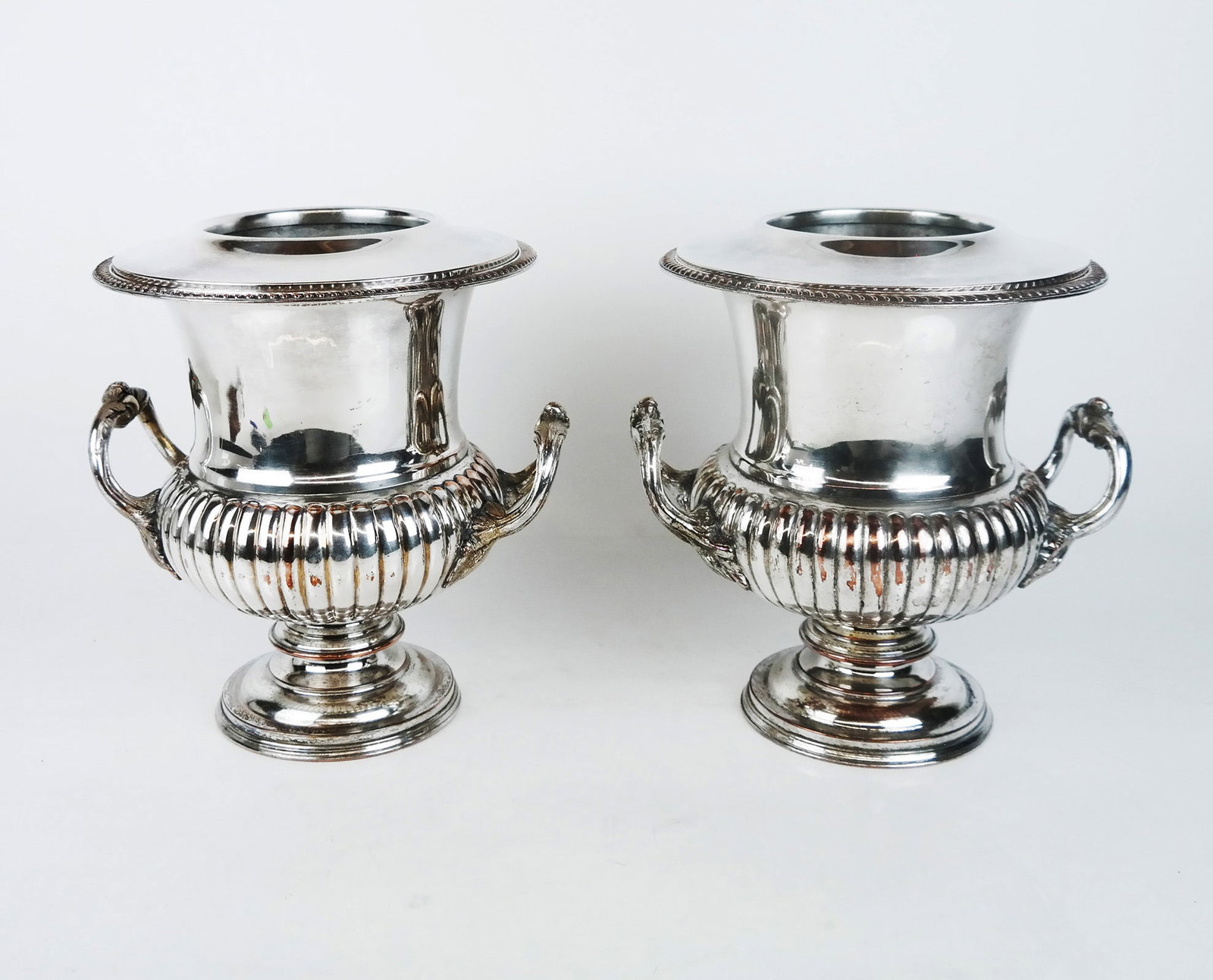 Pair of Sheffield Silver Plate Wine Coolers: Pair of Sheffield silver plate wine coolers, having ribbed bodies, two handles each, and gadroon trim, with wide top liners. [10 1/2" H x 9" Diam.; 10" W across handles].