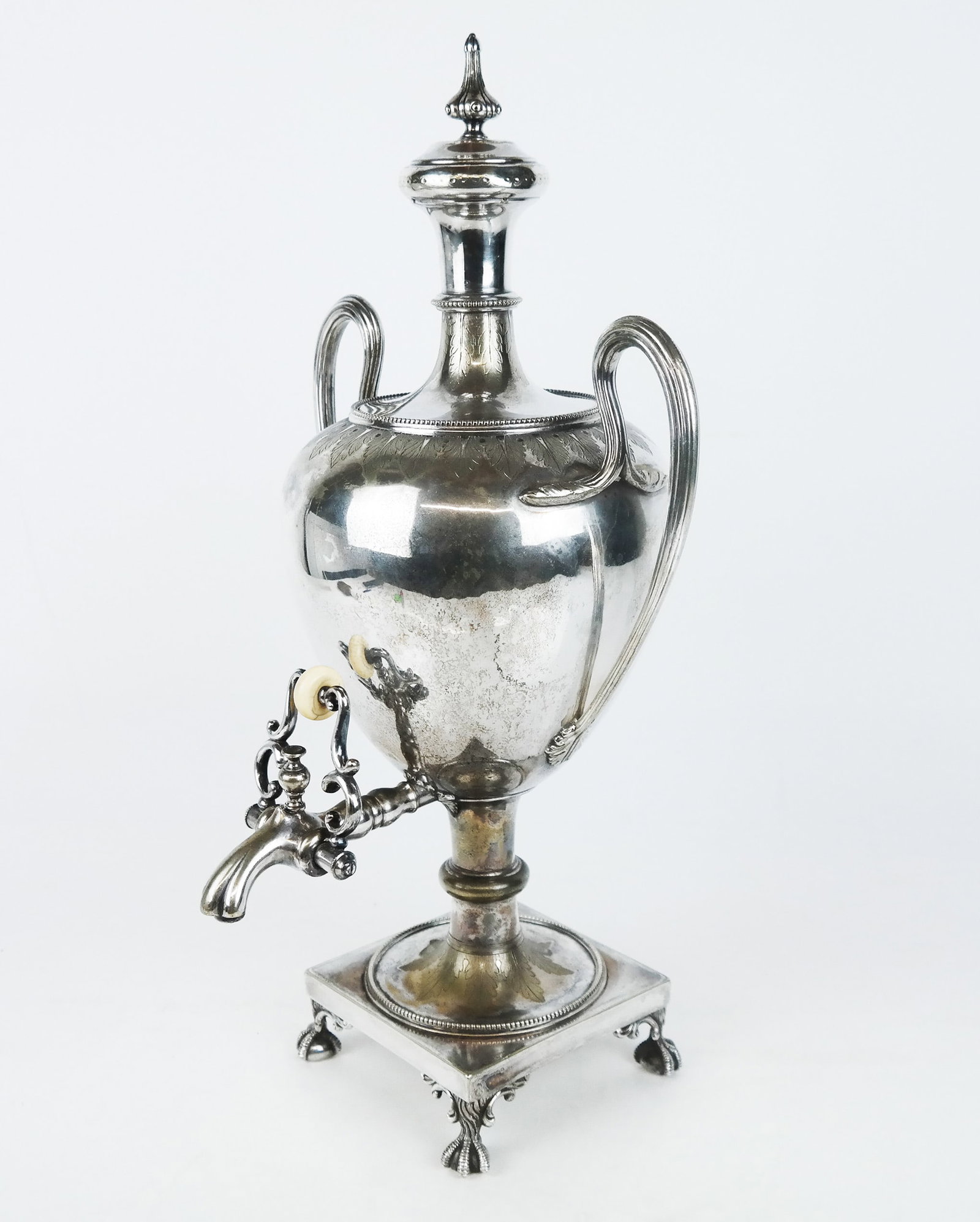 English Silver Plate Hot Water Urn: English silver plate hot water urn, with finial cover, ribbed handles, and incised designs, by Mappin Brothers, London, on ball and claw feet. [18" H x 9 1/2" W x 8 1/2" D].