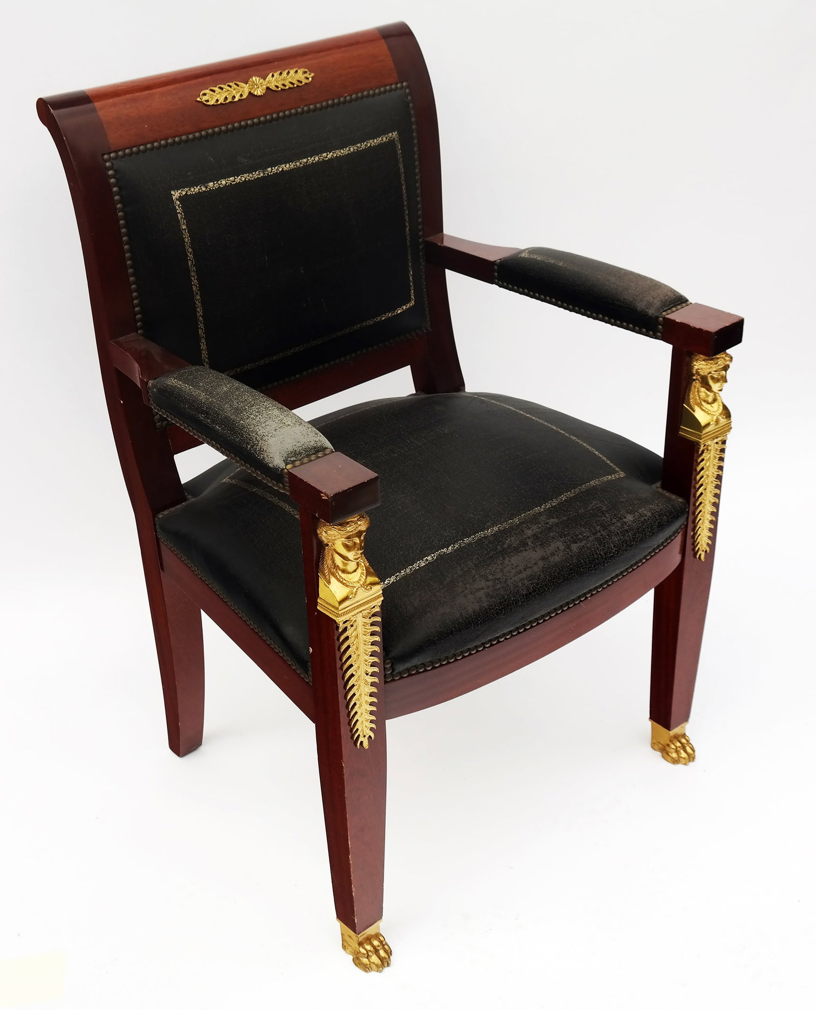 Empire-Style Mahogany Armchair: An Empire-style mahogany armchair with gilt bronze mounted details and brass clavos trim. [37 1/2" H x 25 1/2" W]. Provenance: From the Estate of Baroness Gabriele Langer von Langendorff.