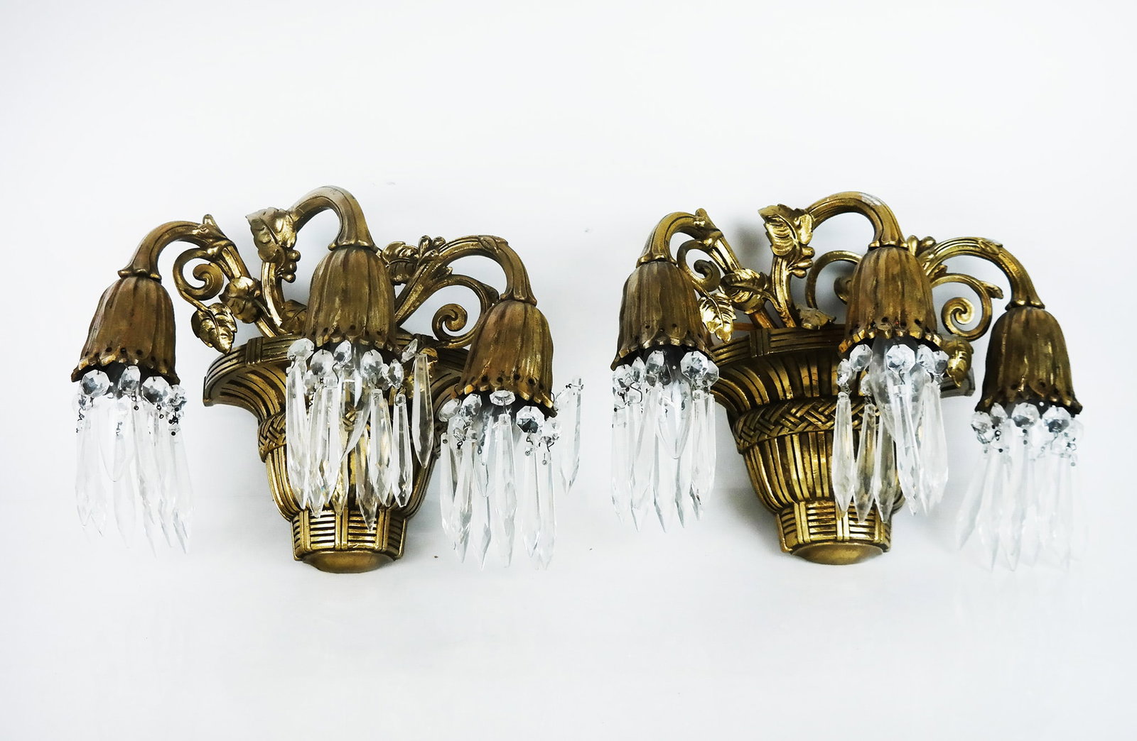 Pair of Gilt Bronze and Glass Sconces: Pair of gilt bronze and glass sconces, modeled as baskets of flowers downswept with faceted prisms. [8 1/2" H x 12 1/2" W x 7" D].