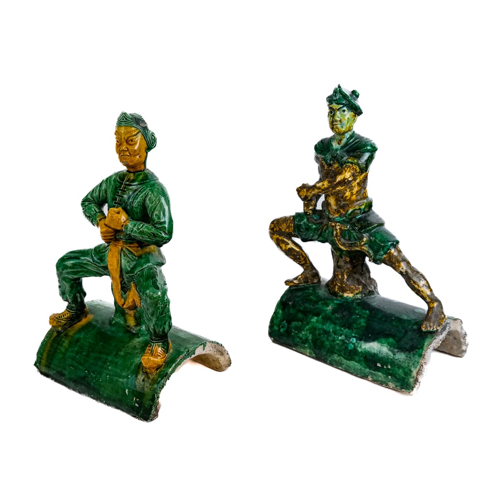 Chinese Sancai Glazed Roof Tiles (2): Two (2) Chinese Sancai glazed roof tiles, after the antique, modeled as action figures. [13 1/4" H x 10" W x 5 1/2" D; 12" H x 7 1/2" W x 5 5/8" D]. One with crack on a leg; some minor paint loss.