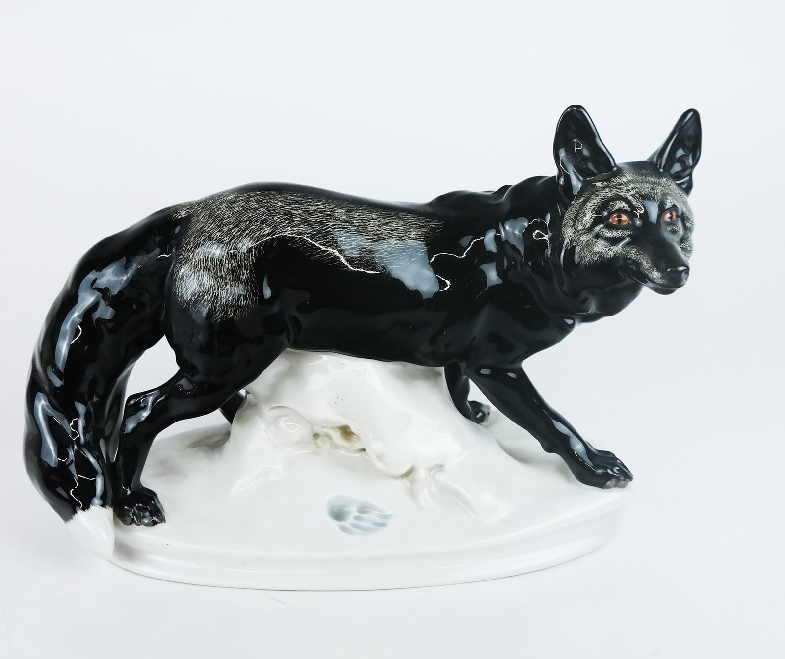 Meissen Figure of a Black Fox: Meissen porcelain figure of a black fox with footprint in snow. [7" H x 10" W x 4 1/2' D (oval base)]. In overall very good condition aside from light dust and residue.