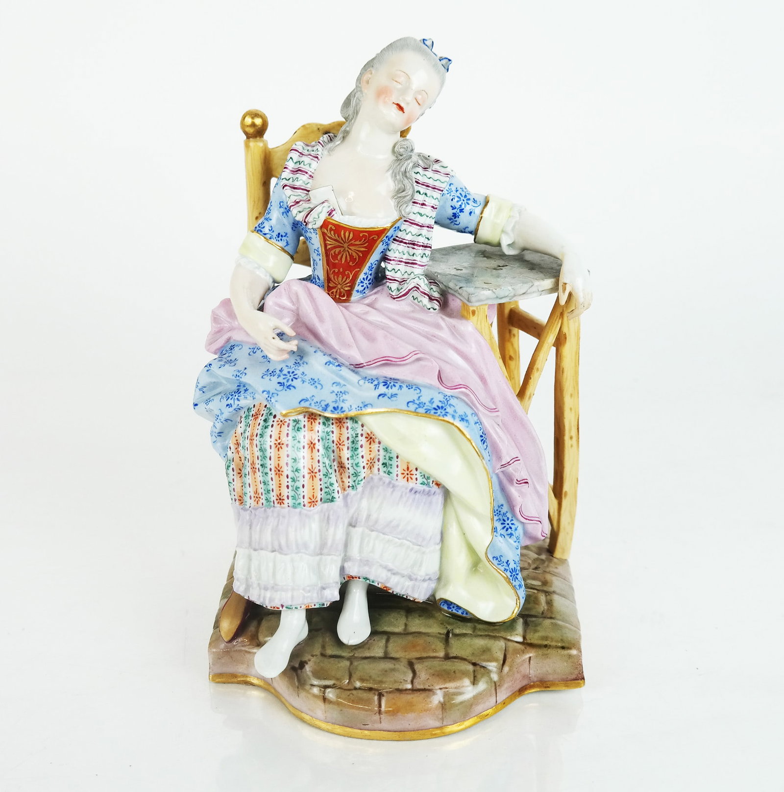 Meissen Figure of a Woman: Meissen porcelain figure of a woman sleeping in an armchair. [8" H x 5" W x 5" D]. Lower right on shoe broken.