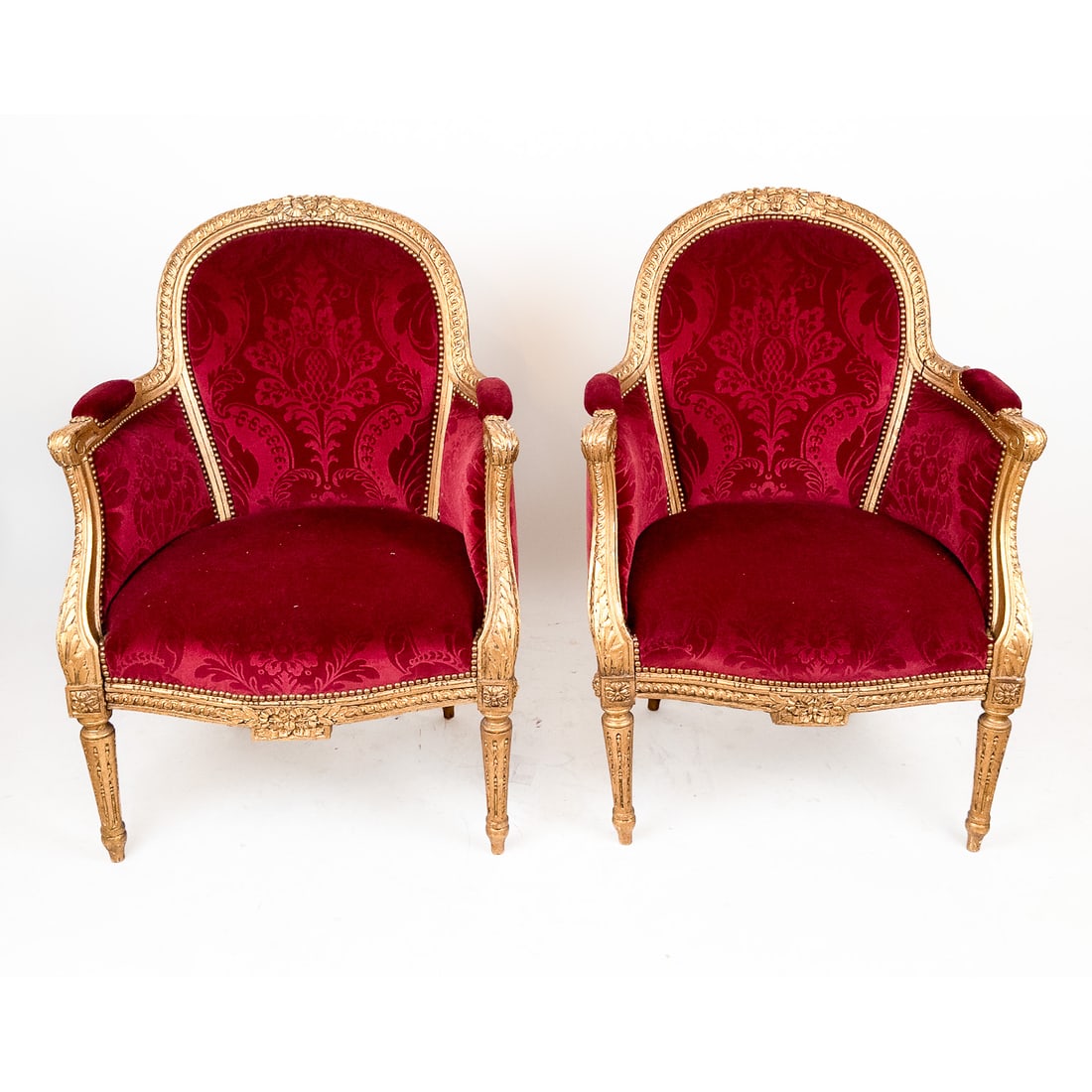 Pair of Louis XVI-Style Giltwood Bergeres: Pair of Louis XVI-style giltwood bergeres with maroon velvet upholstery. [37" H x 27" W x 27" D].
