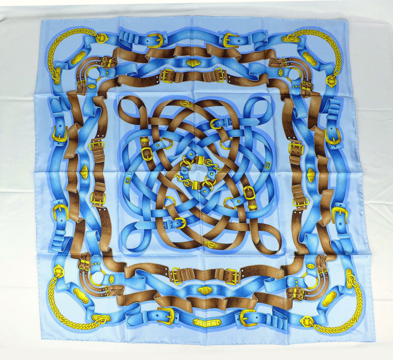 Vintage Gucci Italy Silk scarf New with tags and box "Belts": This is a Gucci Silk Scarf made in Italy dating from the 1990's early 2000's. Decorated with a scroll design of multiple leather chained belts in Blue hues. In new condition with tag box and papers me