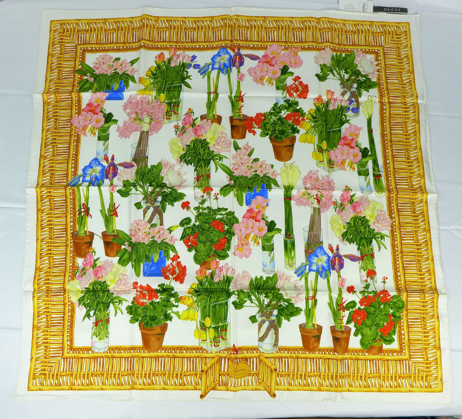 Vintage Gucci Italy Silk scarf New with tags and box "Potted Flowers": This is a Gucci Silk Scarf made in Italy dating from the 1990's early 2000's. Decorated with multiple potted and glass vase colored flowers surrounded by a wicker border. In new condition with tag box