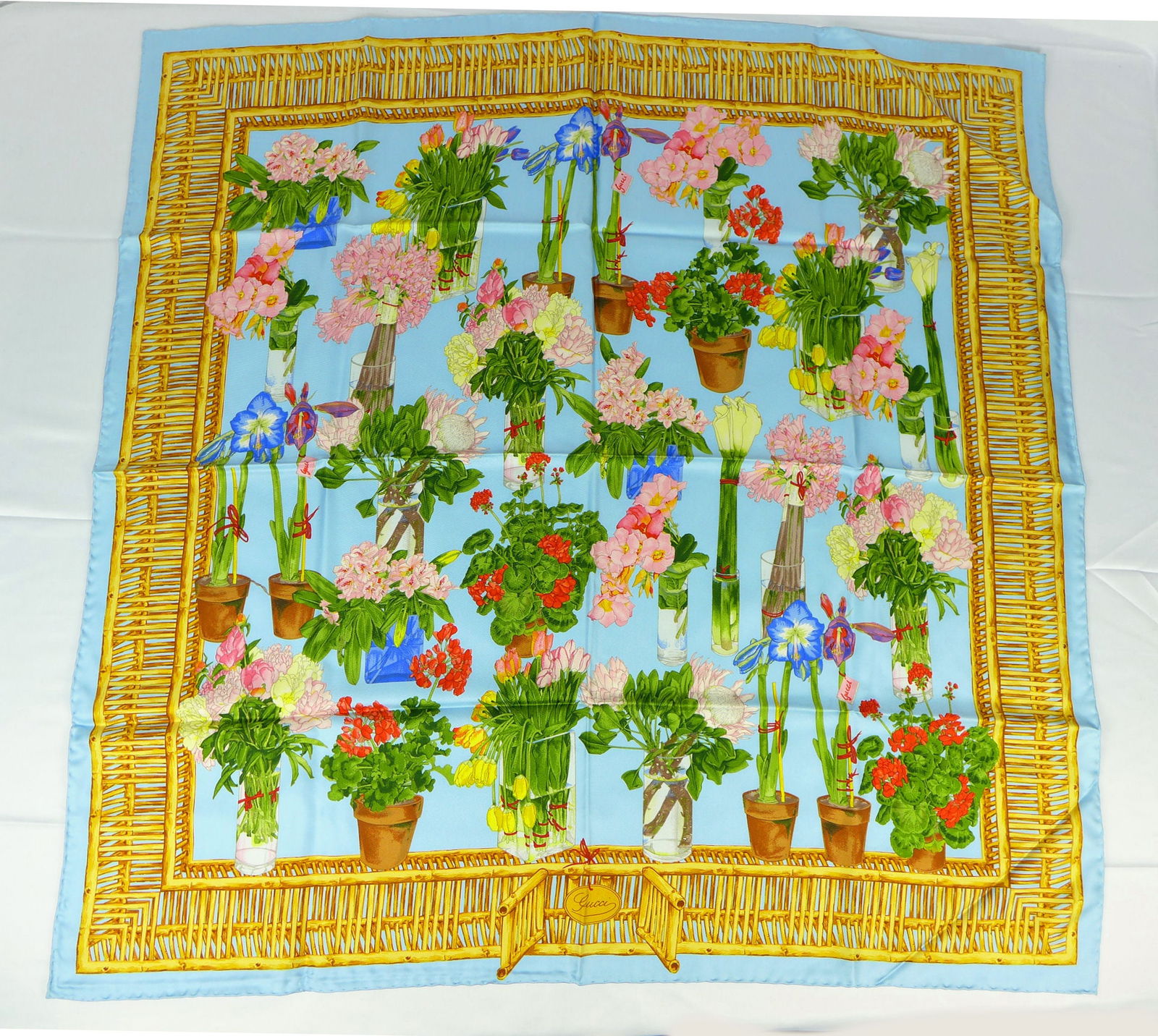 Vintage Gucci Italy Silk scarf New with tags and box "Potted Flowers": This is a Gucci Silk Scarf made in Italy dating from the 1990's early 2000's. Decorated with multiple potted and glass vase colored flowers surrounded by a wicker border n blue background. In new cond