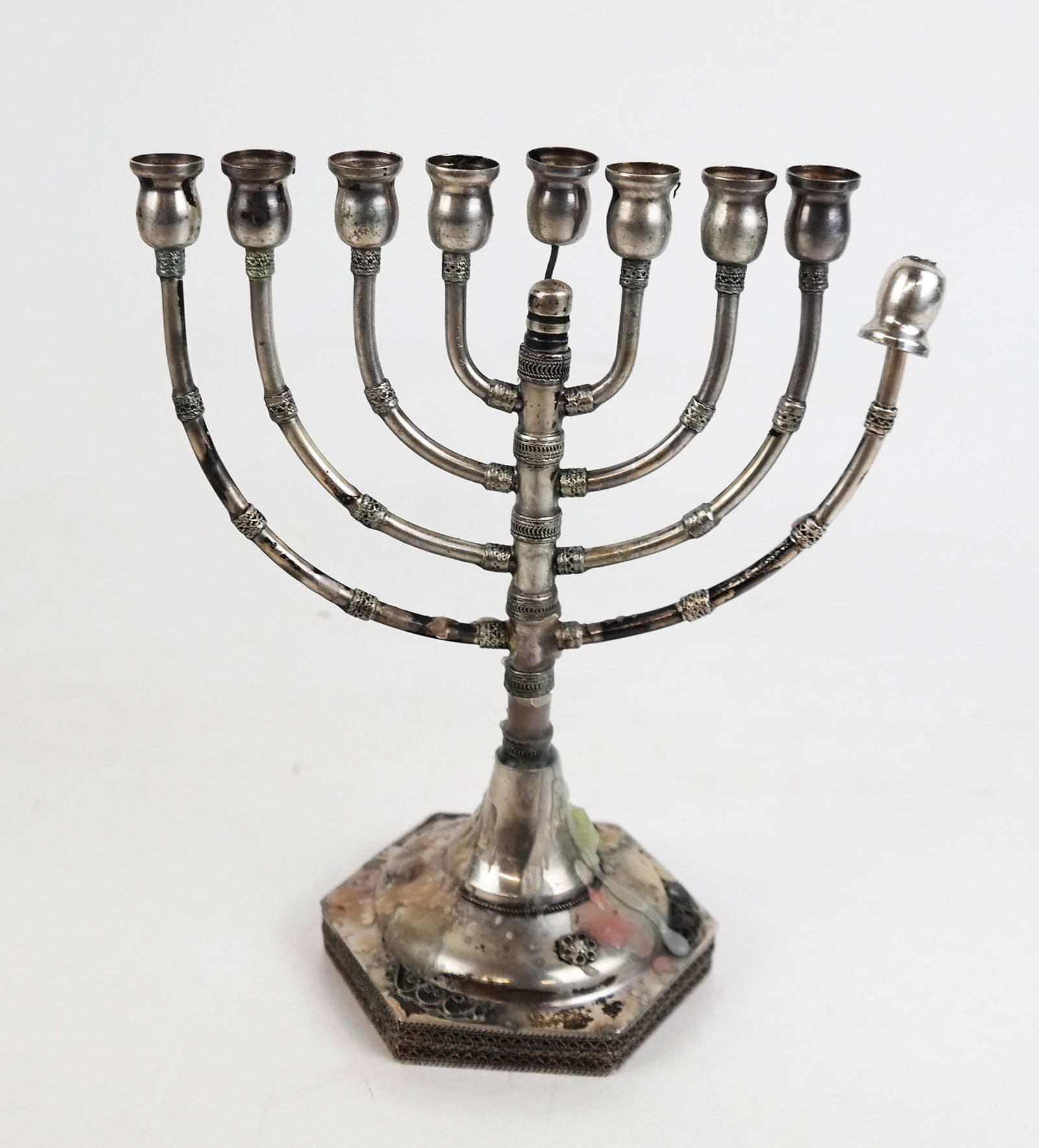 Small Silver Menorah: Small silver menorah with filigree accents. 3.8 ozt. (inclusive of wax). [7" H]. Sold "as-is"; one cup needs repair.