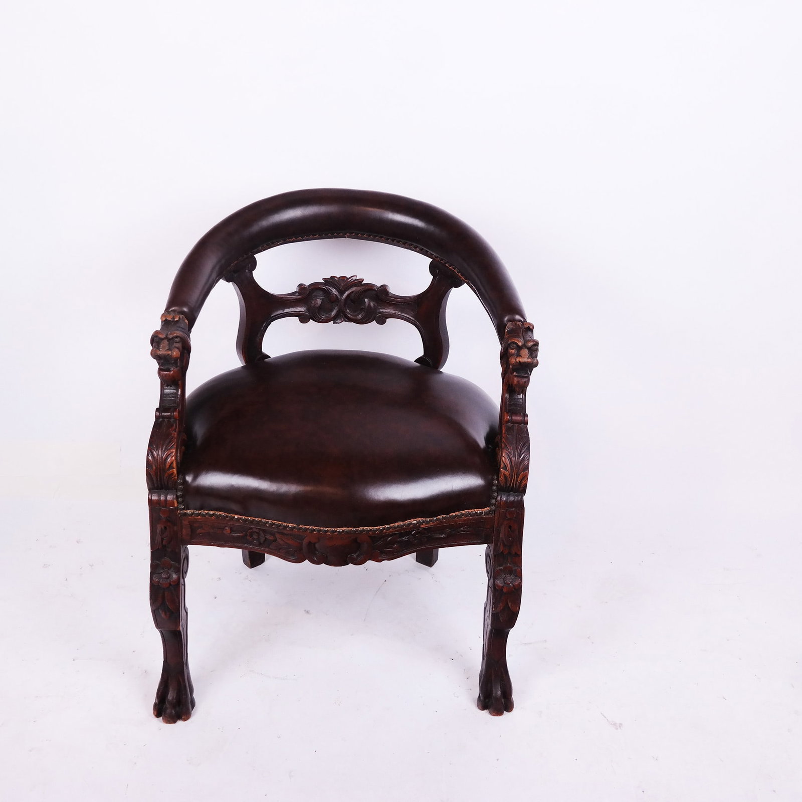 Renaissance Revival Oak Armchair: Renaissance Revival oak armchair, early 20th century, with carved lion and foliate details, raised on paw feet. [30 1/2" H x 24 1/2" W x 23" D]. Recent upholstery; wear and losses to carving.