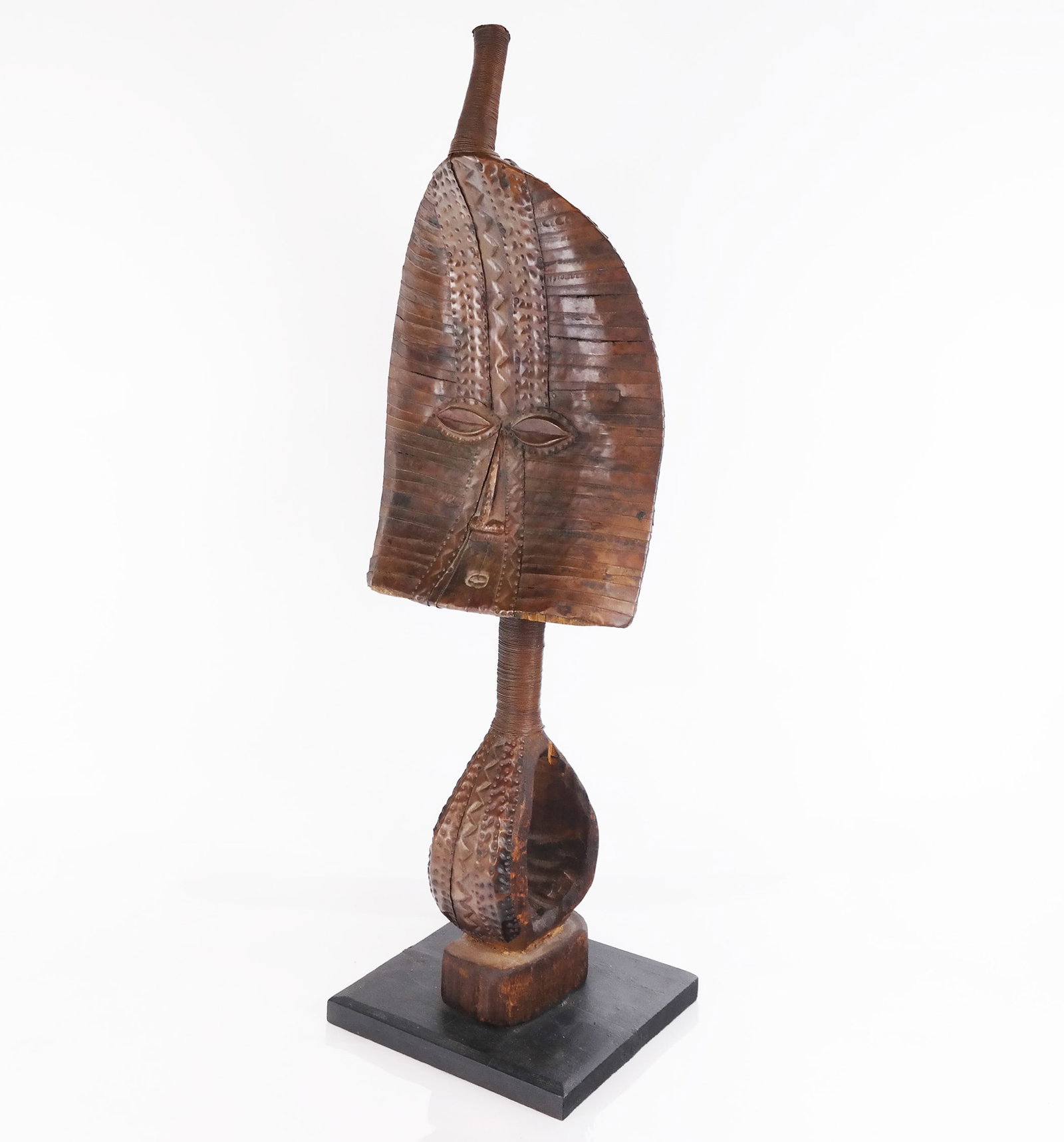 Wood and Metal Kota Figure on Stand: Wood and metal Kota figure on stand, possibly from Gabon, Africa, with coil and hammered metal work. The Kota used guardian figures to protect and identify the revered ancestral remains. [29 1/2" H x 