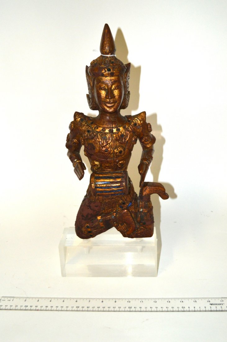 Polynesian Parcel Gilt Carved Wood Figure: Depicts a kneeling musician playing drums. Bears colored glass accents. Some losses and vertical crack at center. 7 3/4" W x 5" D x 17" H. On acrylic base: 20" H.