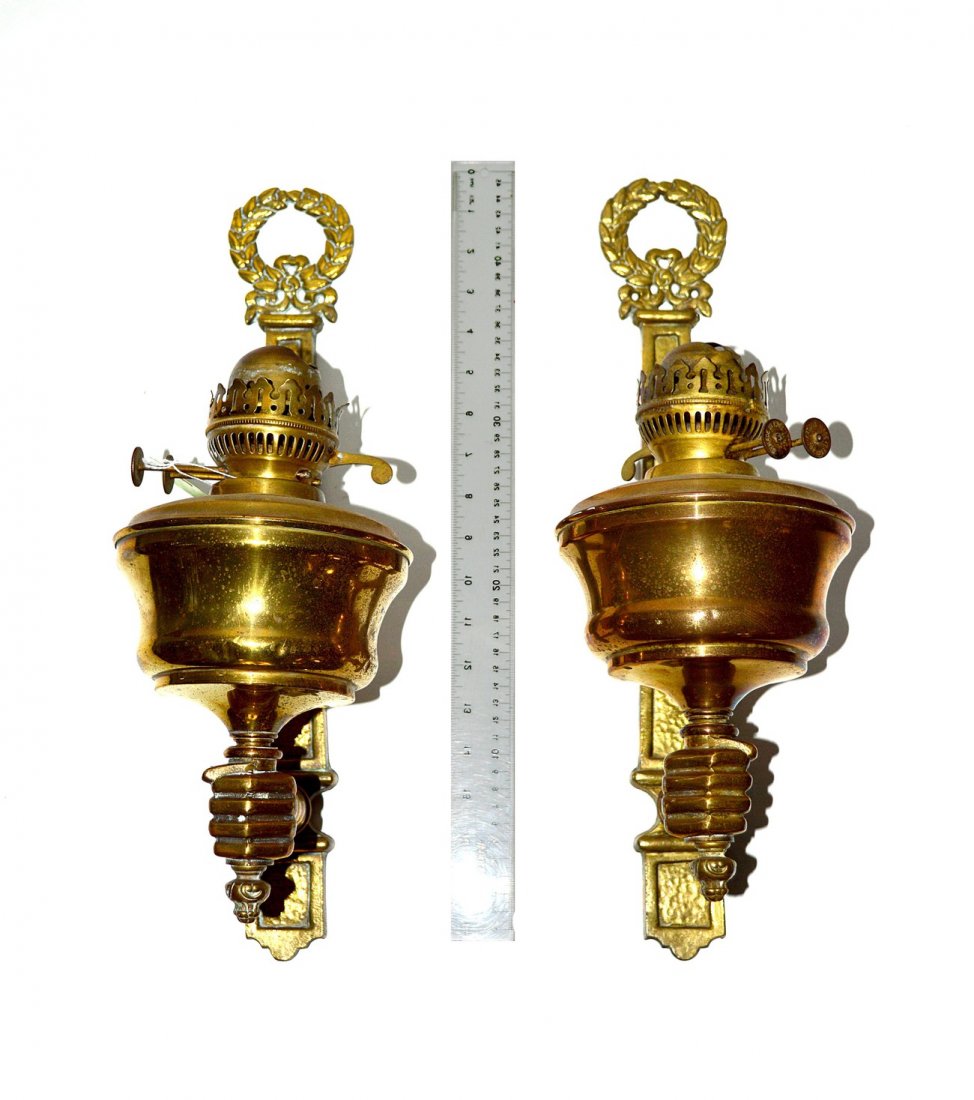 Pair of Vintage Brass Arm & Hand Sconces: Pair of non-electrified oil burning sconces with hand form arms, long back plates, and wreath finial. 6" W x 8 1/2" D x 16 3/8" H. Some wear, otherwise complete.