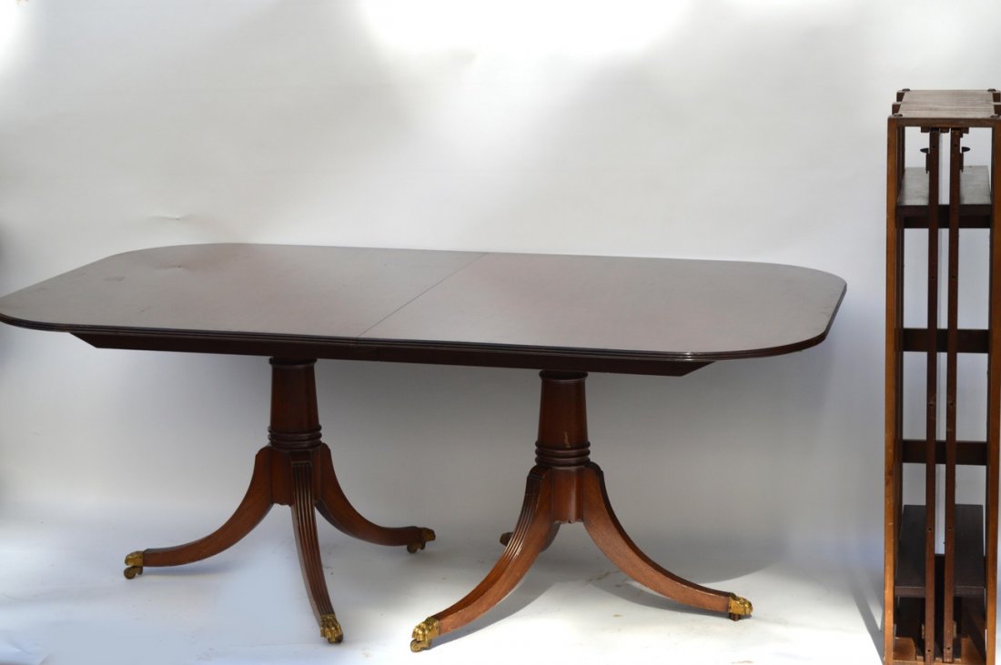 Federal Style Dining Room Table: Mahogany dining room table, features double pedestal bases with splayed legs, terminating in brass lion paws on castor feet. Accompanied by two leaves. Minor defects, including scratches and scuffs. 7