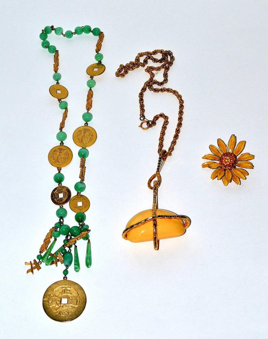 Kenneth J. Lane Costume Jewelry [3]: Comprises: faux Chinese coin and jade necklace, gold tone necklace with large mineral pendant, and an enameled daisy brooch with amber paste stones.