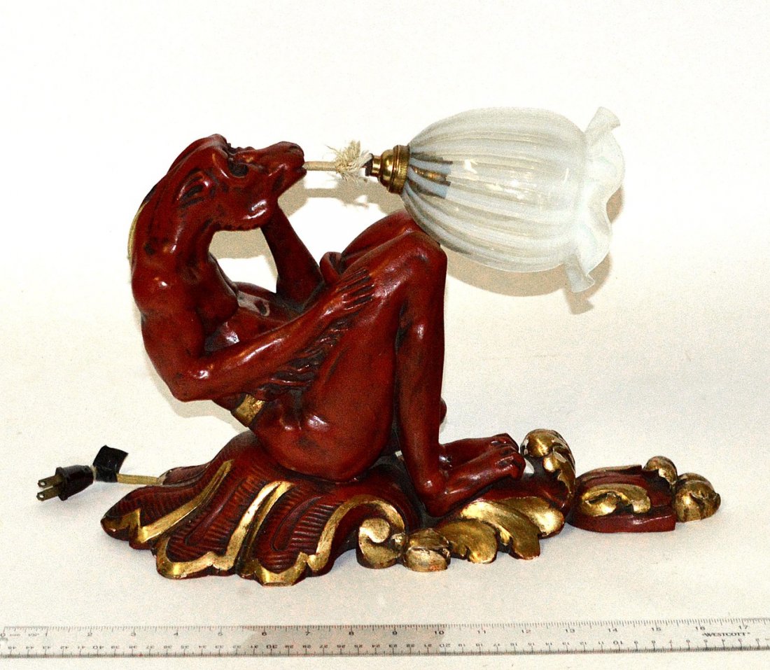 Carved Wood "Demon" Sconce with Tiffany Shade: Art Deco sconce with red painted seated demon issuing a light from his mouth, bearing a Tiffany glass shade. 6 1/2" W x 11 1/2" D x 15 1/2" H. Some chips, needs to be rewired.