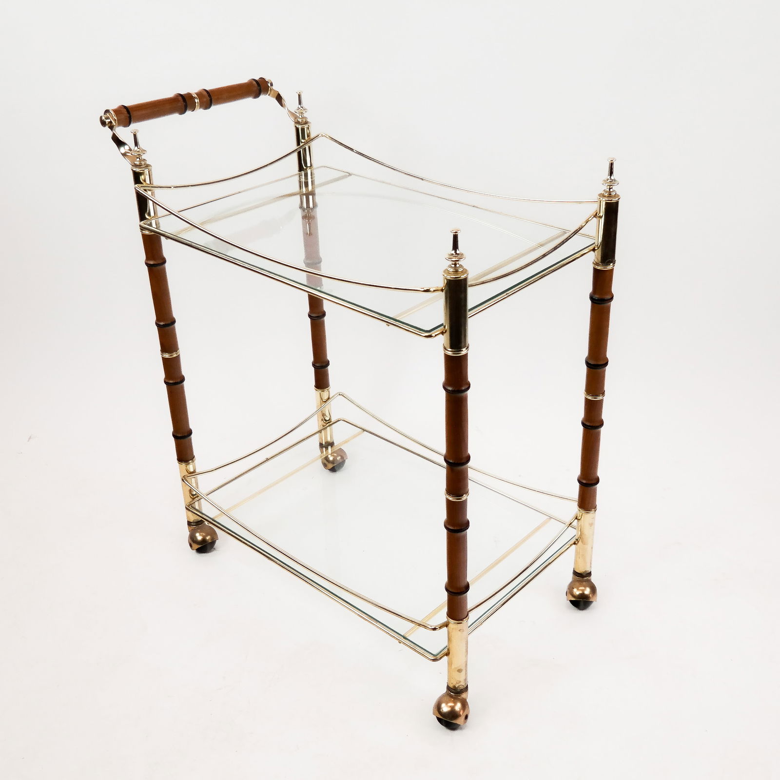Mid-Century Bamboo & Glass Cocktail Cart: Mid-century bamboo and glass cocktail cart with glass shelves and trolley casters. [33" H x 31" W x 17" D].