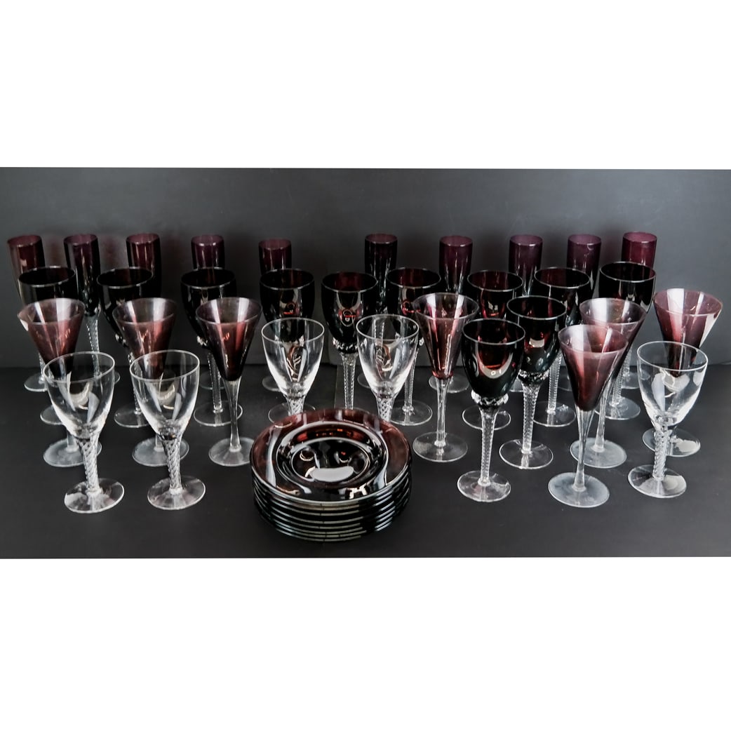 Collection of Amethyst and Clear Glass (30+ Pcs): Collection of variously designed amethyst and clear glass stemware and plates, comprising 5 colorless white wine glasses [7 1/2" H], 11 red wine glasses [9" H], 10 champagne flutes [9" H], dessert gla
