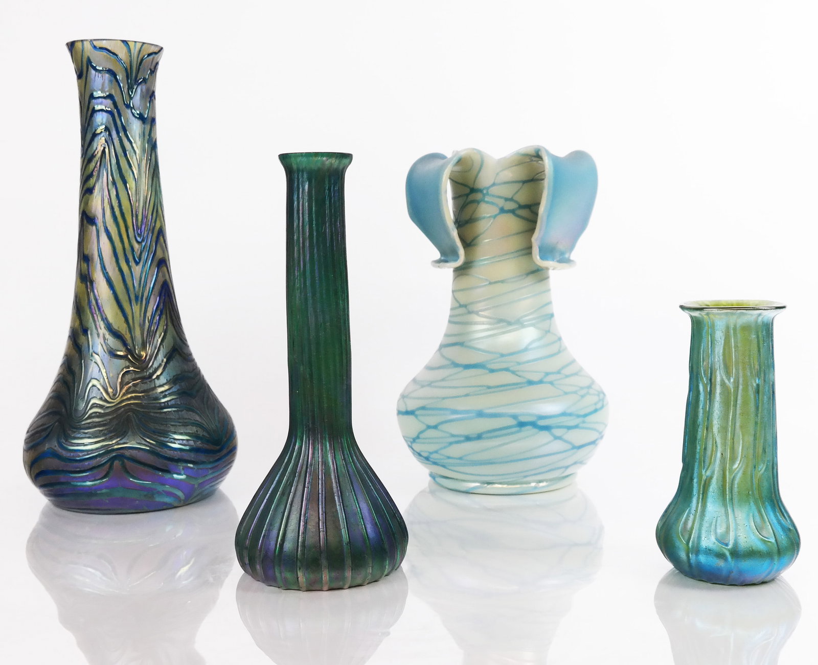 Group of Iridescent Art Glass Vases (4): Group of iridescent art glass vases, variously designed and decorated in shades of blues and greens. [Tallest: 11 1/4" H x 5 1/2" Diam.]. First image left to right - #1 small chips to rim, #2 overall 