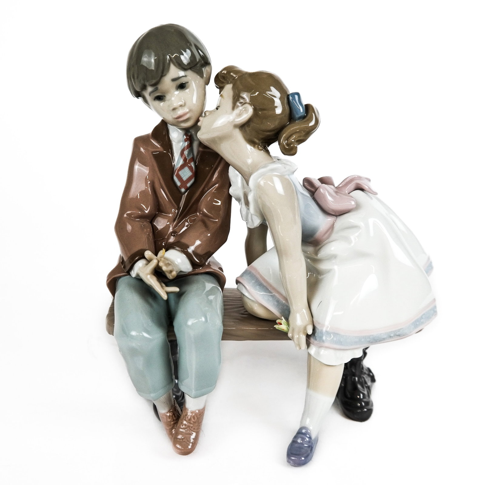 Lladro Spanish Porcelain Figure: Lladro porcelain figure, "Ten and Growing", modeled as young children on a bench, marked to base. [7 3/4" H x 7 1/2" W x 4 3/4" D]. In overall good condition, aside from light residue.