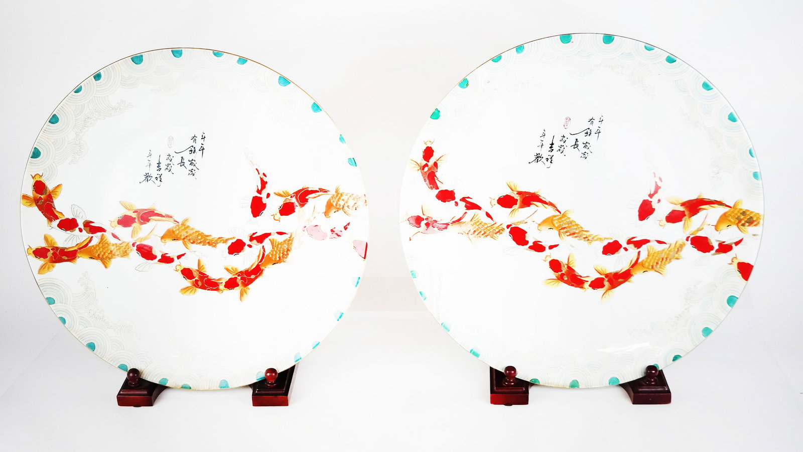 Pair of Large Porcelain Chargers on Stands: Pair of large Chinese porcelain chargers on stands with stylized wave/water border, a stream of koi and motto, on stands. [18" Diam.].